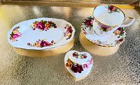 Group shot of teacup with saucer, heart trinket box, oval butter dish