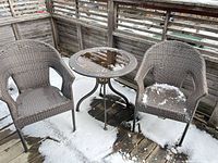 Full view of two chairs and side table on patio