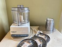 Overall view of food processor with bowl, pusher, three discs, disc stem