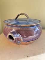 Lidded stoneware soup tureen front view showing glaze and side spout