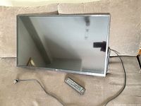 Front view of LG flat screen with remote and power cord