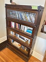 Front view showing four sections, leaded glass top door, clear glass lower doors, bottom drawer