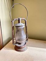 Full view of kerosene lantern showing frame, globe, bail handle and base