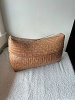 Front view of closed oval lidded basket showing weave and color