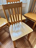 Front view of one chair showing slat back and seat surface