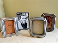 Front view of all four pewter frames showing shapes and photo openings