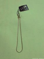 Full view of gold-tone chain bracelet with tag attached