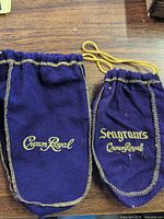 Front view of both purple drawstring bags showing logos