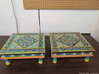 Pair of painted wooden risers on table, full view