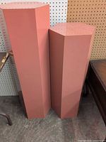 Front view of both pink hexagonal pedestals standing side by side