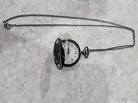 Pocket watch open showing dial and chain