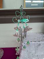Full view of wind chime hanging, showing frame, tubes, flowers, leaves, ornaments