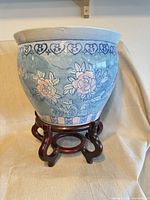 overall view of porcelain planter on wooden stand showing floral design