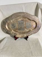 Full view of oval copper tray on stand showing overall form and etched motifs