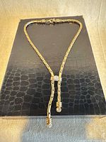 Full view of gold-tone lariat necklace laid flat