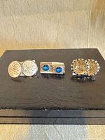 Front view of all three cufflink pairs showing face designs