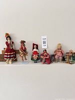 All six dolls lined up on shelf