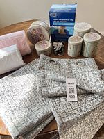 Lot overview showing towels, curtains, nesting tins, Exact oat bag box