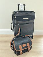 Suitcase standing with camera bag in front