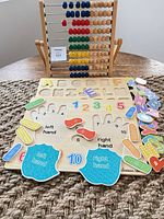 Abacus and puzzle board with loose letter, number and hand pieces displayed