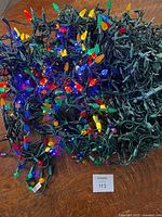 Overview of tangled multicoloured and white string lights on table