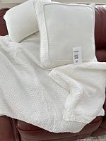 Comforter draped over sofa with two pillows and sham displayed