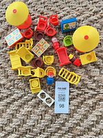Overhead view showing all 23 Fisher Price Little People accessories on rug