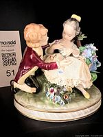 Full view of porcelain figurine showing courting couple and base