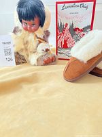 Doll, moccasin, and packaging group shot