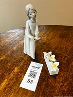 Lladro figurine and Royal Albert trillium floral arranged side by side with lot tag visible