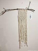 Full view of macrame wall hanging on branch