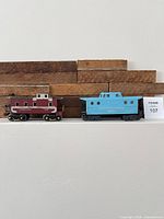 Both Lionel cabooses side by side on shelf