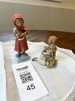 Both Precious Moments figurines side by side on cloth