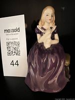 Front view of Royal Doulton “Affection” figurine beside lot card