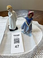 Both Royal Doulton figurines on table linen