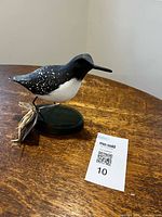 Full view left profile of sandpiper carving on base with tag