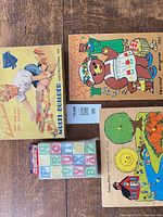 Overall lot showing Multi Builder box, Dress-Up Bear puzzle, sealed alphabet blocks, and Matching Colors puzzle pieces