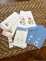 All seven embroidered finger towels arranged on surface