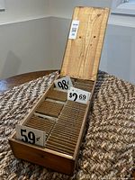 Open wooden box showing dividers and assorted price tags such as 59¢, 98¢, $2 69