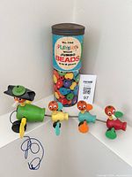 Overall lot: Fisher-Price Gabby Duck Family pull toy and Playskool Wood Jumbo Beads tube