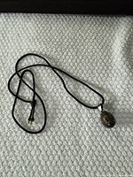 Pendant necklace full view on textured surface