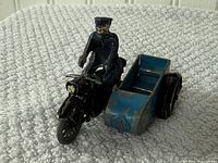 front angled view showing rider, motorcycle, and blue sidecar