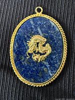 Front view showing dragon motif on blue stone with gold-tone border