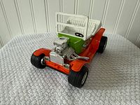 front three-quarter view showing chrome engine, grille, orange front, black tires