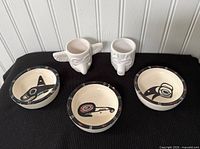 set of two white animal-head cups and three painted bowls