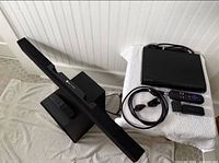 Overall view of Samsung soundbar on subwoofer next to Sony player and Roku accessories