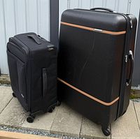 Both pieces of luggage side by side showing relative sizes and wheel bases