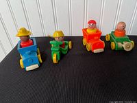 Group of four Little People vehicles with figures seated