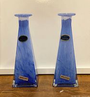 Front view of two blue Murano glass vases with labels