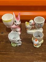 All four ceramic figural egg cups displayed together